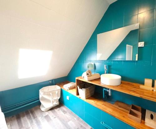 une salle de bain bleue avec des toilettes et un lavabo dans l'établissement La Capitainerie - Duplex 2 chambres et coin nuit à 5min à pied de Nausicaa, plage, centre Ville - Côte d'Opale, à Boulogne-sur-Mer