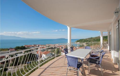 a balcony with a table and chairs and the ocean at Three-Bedroom Apartment In Podaca in Podaca