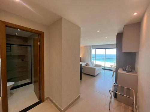 a living room with a view of the ocean at Lindo Flat na praia de Itaipuacu in Maricá