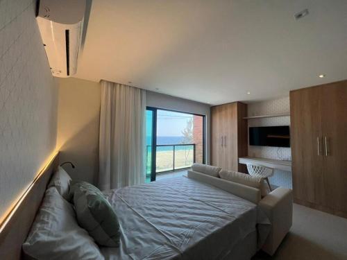 a bedroom with a large bed and a large window at Lindo Flat na praia de Itaipuacu in Maricá