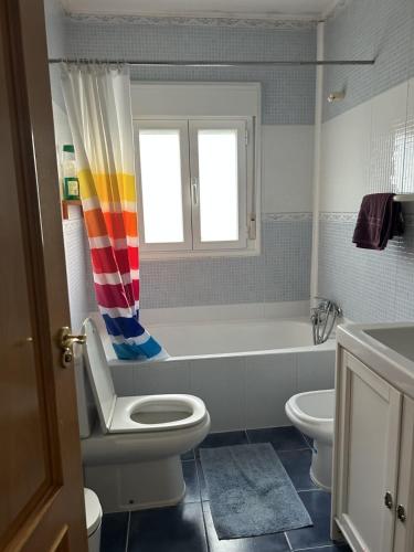Un baño con inodoro, bañera y lavabo. en CasitaAzul double room, en Cáseda