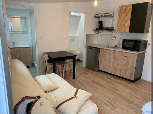 un salon avec un canapé et une cuisine dans l'établissement Studio T2 vacances, à Marseille