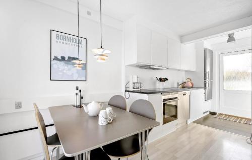 a kitchen and dining room with a table and chairs at Cozy Apartment In Allinge in Allinge