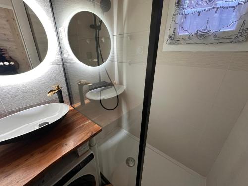 une salle de bain avec un lavabo et un miroir dans l'établissement Studio confortable avec grande terrasse ensoleillée, proche commerces et téléphérique. - FR-1-464-2, à Pralognan-la-Vanoise