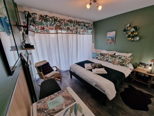 Un dormitorio con una cama y una silla dentro. en L'Aixotique, en Aix-les-Bains