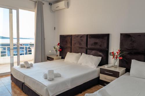 a bedroom with two beds with a view of the ocean at Hotel Myrtai - City Center in Sarandë