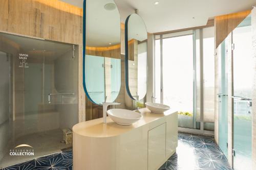 a bathroom with two sinks and two mirrors at Maritima Playa Luxury Condo 6O in Bucerías