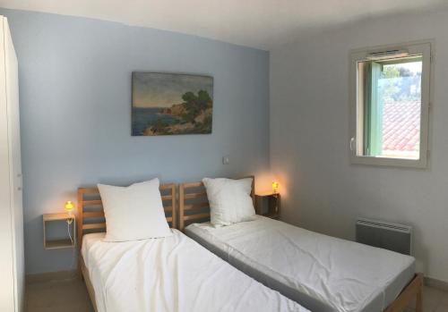 deux lits jumeaux dans une chambre avec fenêtre dans l'établissement Espace et confort à Porquerolles, à Hyères