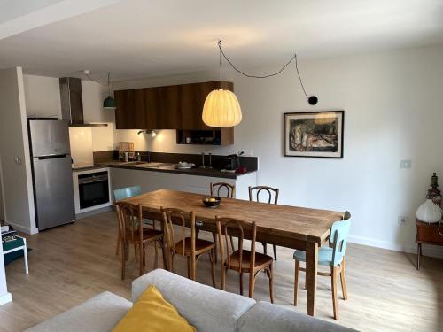 une cuisine et une salle à manger avec une table et des chaises en bois dans l'établissement Espace et confort à Porquerolles, à Hyères