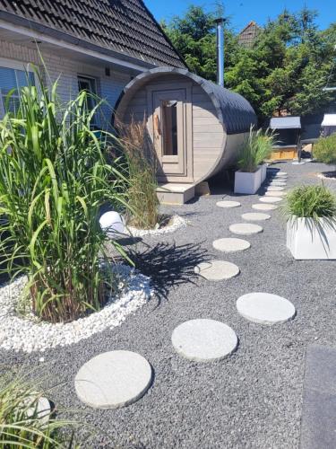 a garden with a circular building with a round house at Strandmuschel in Aventoft