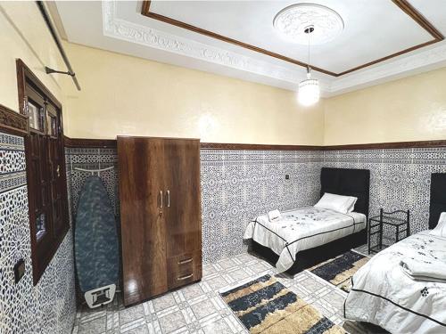 a bedroom with two beds in a room with tiles at Maison de Vacances Idéale à 10 min de l'Aéroport in Marrakech