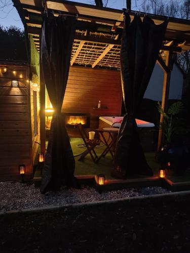 une pergola avec une table et une cheminée dans la cour dans l'établissement Cabane O Chalet, à Voué