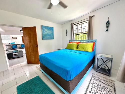 a bedroom with a bed with blue sheets and yellow pillows at South Coast - Private in Christ Church