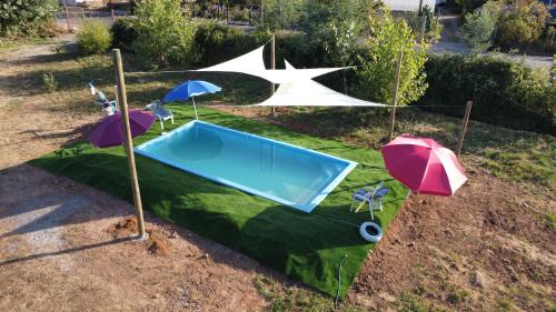 an artificial pool with umbrellas on a field at Cabañas Lomas de Putagan in Linares
