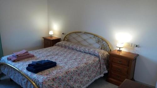 a bedroom with a bed and two night stands with lamps at Agriturismo IL CERRO in Marzabotto