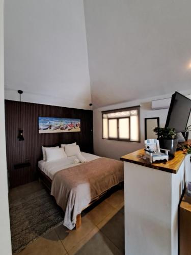 a bedroom with a bed and a desk with a television at Zoa Villas - Santa Teresa - 2 min walk to beach in Santa Teresa Beach