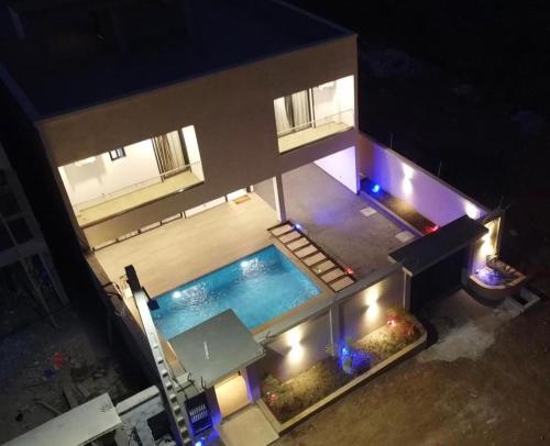 Una vista aérea de una piscina por la noche. en les Résidences Lorenzini, en Yamoussoukro