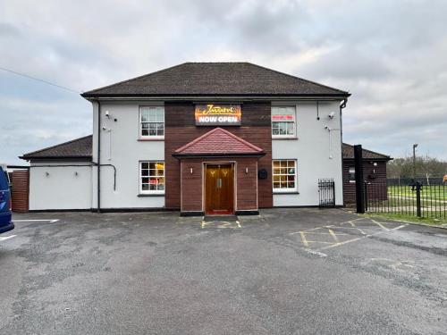 a building with a sign on it in a parking lot at The Bell and Bottle in Hedgerley