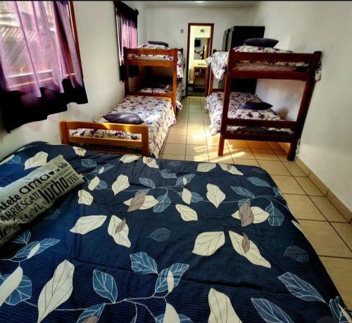 a bedroom with two beds and a blue blanket at Hostel Argentino & camping in Río Grande