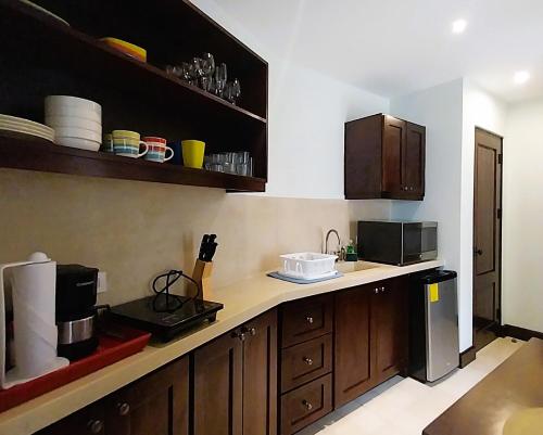a kitchen with wooden cabinets and a counter top at Las Catalinas - Studio Cazenovia centrally located, short walk to beach in Playa Danta