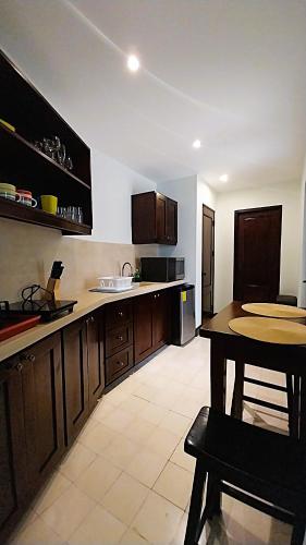 a kitchen with wooden cabinets and a table in it at Las Catalinas - Studio Cazenovia centrally located, short walk to beach in Playa Danta