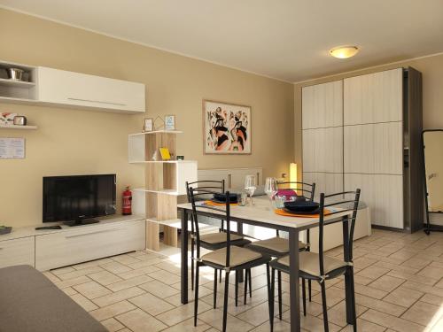 a living room with a table and chairs and a television at Belgioioso Apartments - Monolocale in Belgioioso