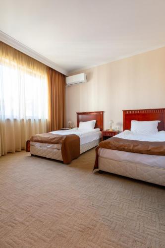 a hotel room with two beds and a window at Downtown Bansko Resort in Bansko