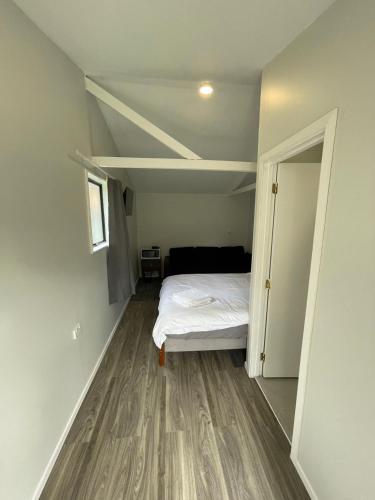 an empty room with a bed and an open door at 2 Double Beds including 1 Sofa Bed Garden Charlet unit C, 9 Steles Lane, Rotorua in Rotorua