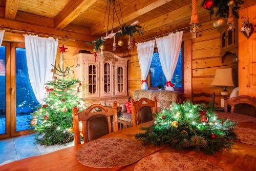 a dining room with christmas trees in a cabin at Leśny Zakątek Jurków in Jurków
