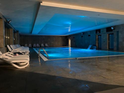 a large swimming pool with a blue ceiling at Black & White Dziwnów in Dziwnów