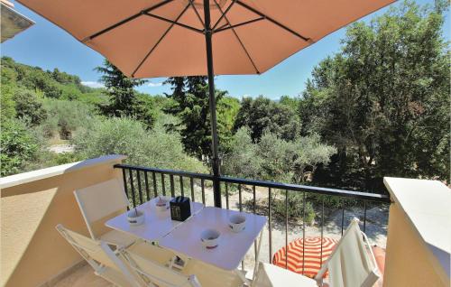 einen Tisch und Stühle auf einem Balkon mit Sonnenschirm in der Unterkunft 3 Bedroom Cozy Home In Mormoiron in Mormoiron