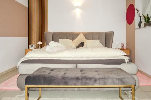 a bedroom with a large bed with a bench next to it at Homestay - Stilvolle Wohnung in Top Lage in Büdingen
