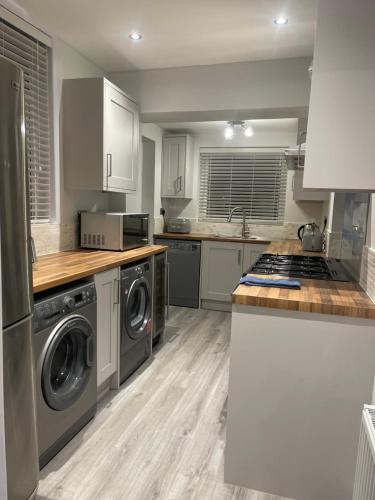 a kitchen with a washer and dryer at Escape to the Beach in Poole