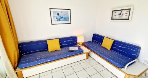 Cette chambre comprend 2 bancs bleus avec des oreillers jaunes. dans l'établissement 