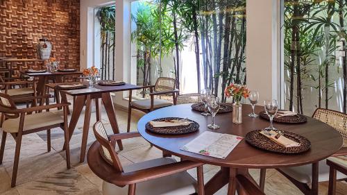 a dining room with tables and chairs and plants at Villa Raphael in Búzios