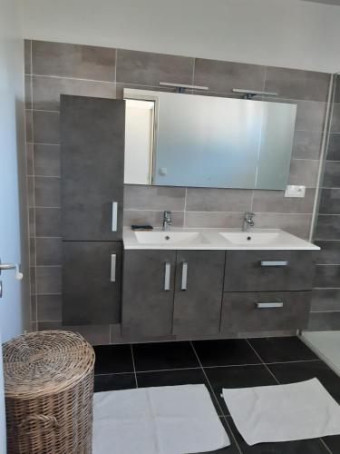 une salle de bain avec un lavabo et un miroir dans l'établissement La route des Genêts, à Locronan