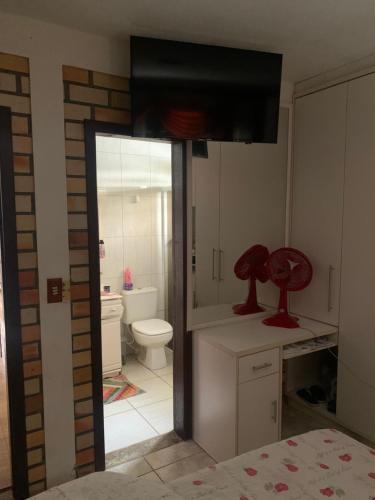 bagno con servizi igienici e TV. di Casa família com piscina a Garopaba
