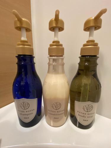 three bottles of liquid sitting on a shelf at Royal Twin Hotel Kyoto Hachijoguchi in Kyoto