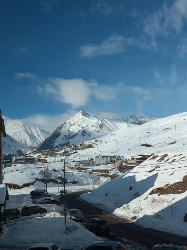a snow covered mountain with a town in the foreground at New Twins 333 in Gudauri