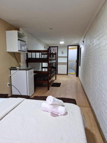a bedroom with a bed with towels on it at Paz e Amor Suite in Abraão