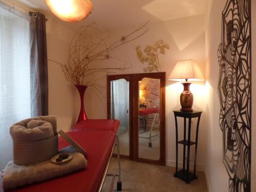 - un dressing avec un miroir et un banc rouge dans l'établissement L'Instant pour Soi, à Saint-Gervais-les-Trois-Clochers