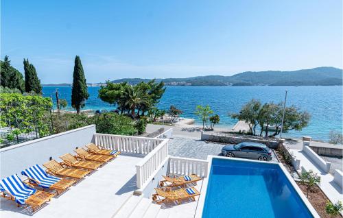 una piscina con sedie e vista sull'oceano di Awesome Home In Kuciste With Wifi a Kučište