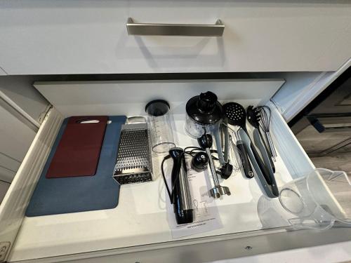 a drawer filled with kitchen utensils on a shelf at Escape to the Beach in Poole