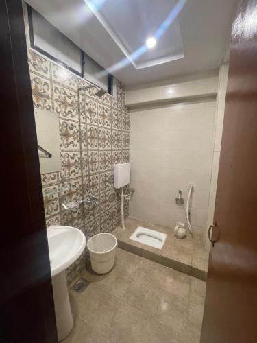 a bathroom with a toilet and a sink at Mussiaree Hotel in Murree