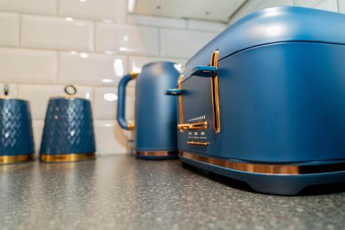 a row of blue toasters sitting on a counter at Central Oxford Apartments Terrace in Oxford