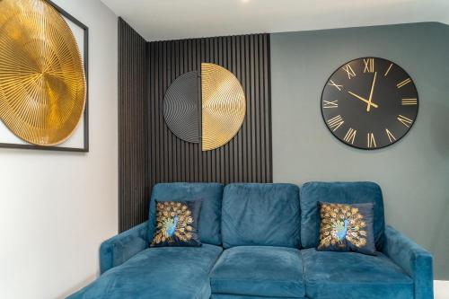 a blue couch in a living room with a clock at Central Oxford Apartments Terrace in Oxford