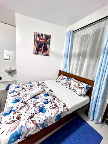 モンバサにあるBstan Airport Studio Apartmentのベッドと窓のある寝室
