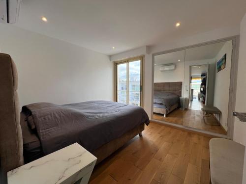 une chambre avec un lit et un grand miroir dans l'établissement Sea view, top floor facing Port Canto in Palm Beach, à Cannes