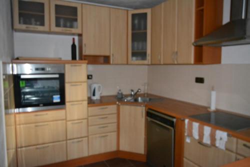 a kitchen with wooden cabinets and a stove top oven at Chalupa v Hatích in Herálec