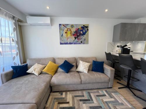 - un salon doté d'un canapé avec des oreillers bleus et jaunes dans l'établissement Sea view, top floor facing Port Canto in Palm Beach, à Cannes